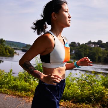 woman running along a river trail wearing a properly fitting sports bra